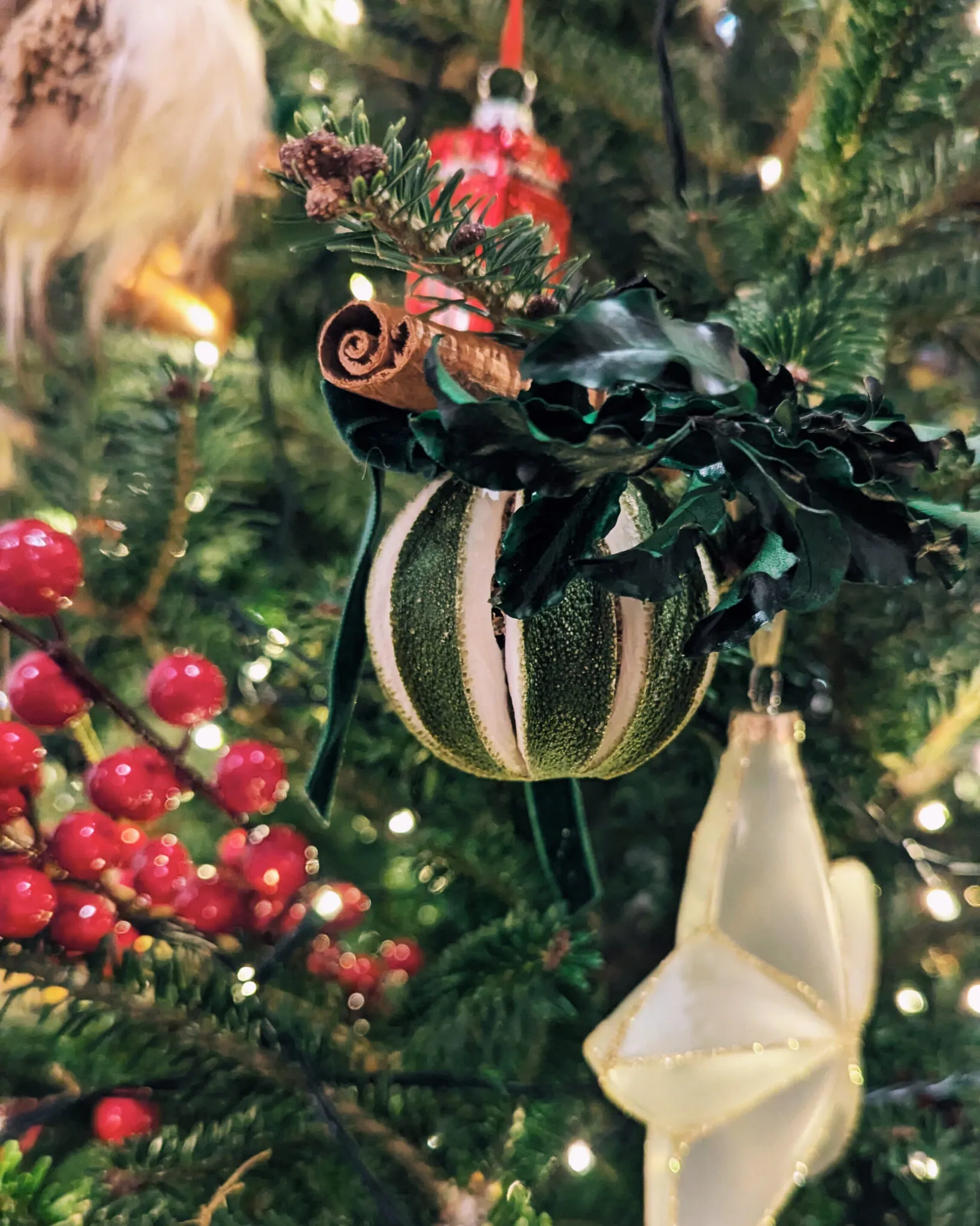 Natural Christmas baubles with dried green oranges, pittosporum foliage and cinnamon sticks with velvet ribbon handmade in London - image 5